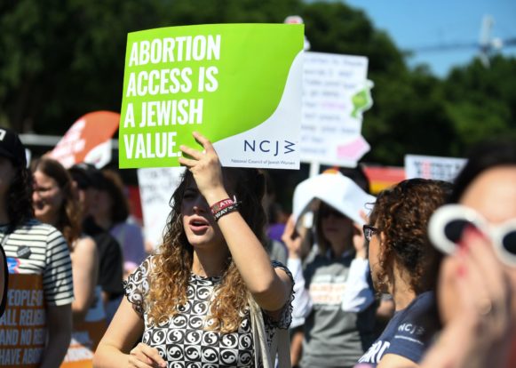 Rallygoers hold up a sign saying "abortion access is a Jewish value."